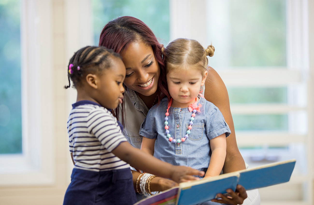 A Child Care Provider Reading Books Together with toddlers