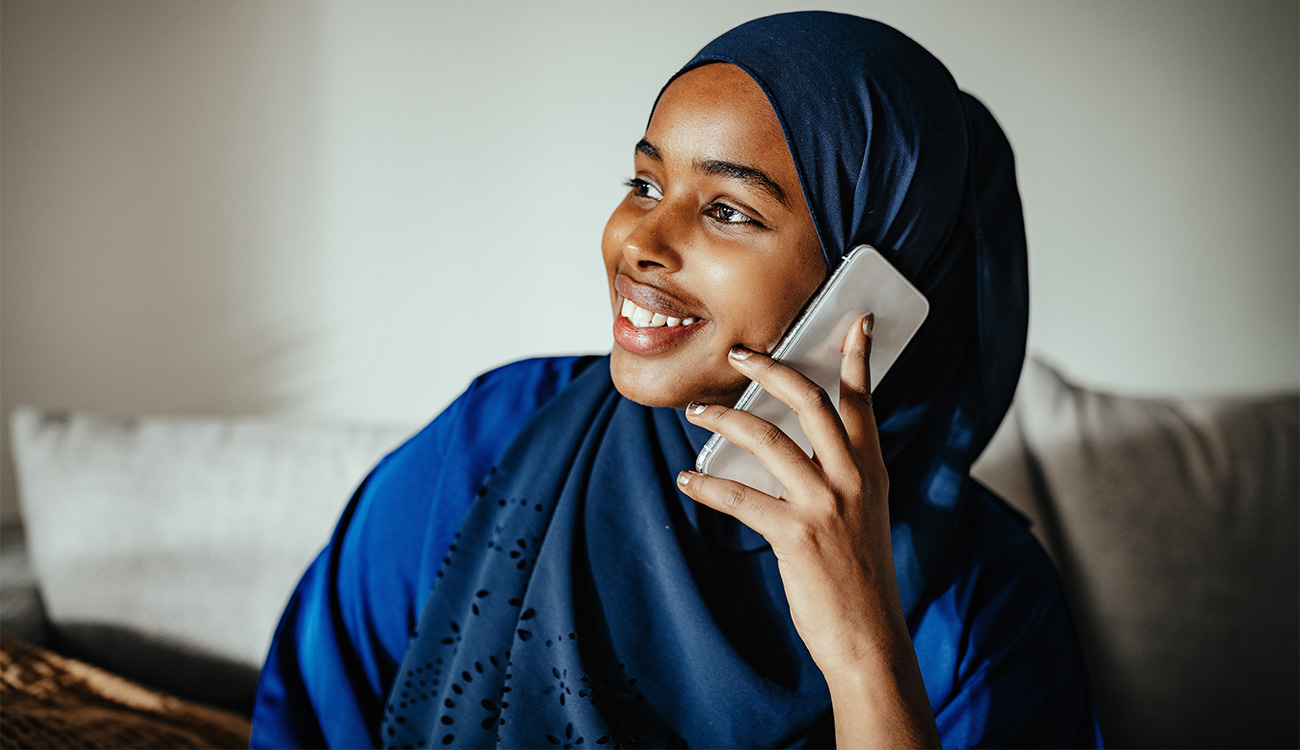 Young Middle Eastern woman with hijab using smart phone